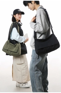 Detail of olive green and black canvas messenger bags with adjustable straps shown on models