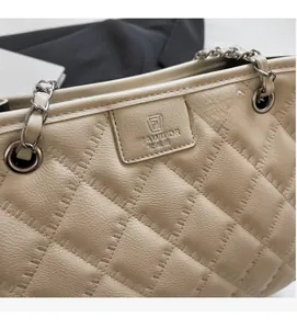 Détail d'un sac à bandoulière en cuir matelassé beige avec chaîne et logo de marque
