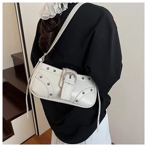 Sac sous le bras beige chic avec rivets argentés montré de dos porté par un mannequin