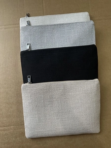 Détail de quatre pochettes en toile avec fermeture éclair en beige, gris, noir et avoine