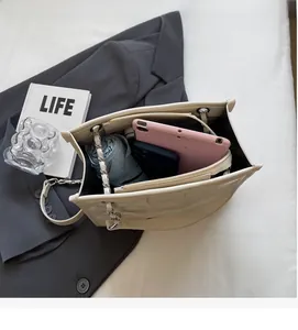 Vue intérieure du sac cabas matelassé blanc cassé avec grand espace et compartiment zippé