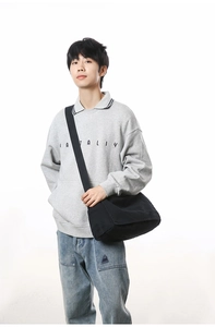 Male model wearing minimalist black canvas messenger bag for casual commuting style