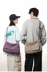 Macro view of canvas messenger bags in purple and khaki with functional side pockets