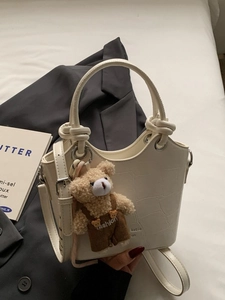 Chic white crocodile-embossed bucket bag with cute bear charm and silver hardware