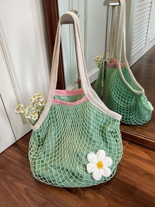 Eco-friendly green cotton mesh shopping bag with white daisy detail and pink trim
