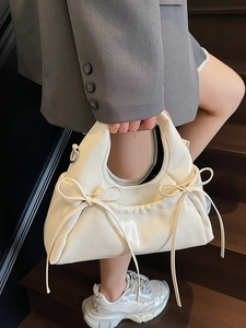 Cream pleated dumpling handbag with glossy finish and ribbon bow accents for women
