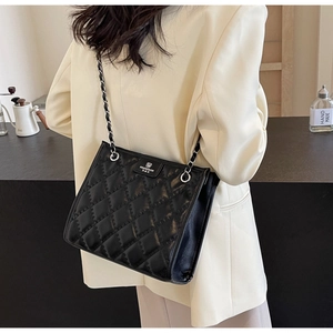 Détail du sac cabas matelassé noir avec bandoulière en chaîne et logo de marque