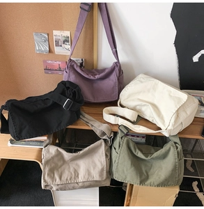 Detailed flat lay of canvas messenger bags in purple, black, beige, khaki, and green colors