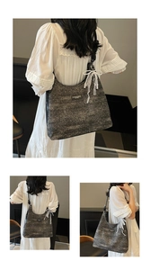 Detail of tweed tote bag featuring white lace bow and pearl charm with black leather strap