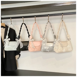 Close-up of stylish mini underarm bags in five colors with woven straps and lace bows