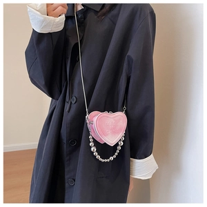 Detail of pink gradient heart-shaped mini bag with embossed letters and chain strap