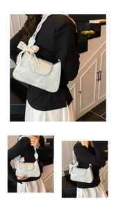 Detail of light green marble-patterned underarm bag with braided strap and lace bow