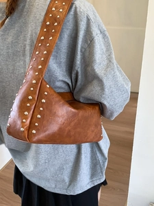 Brown hobo shoulder bag with silver studs and a minimalist vintage punk aesthetic