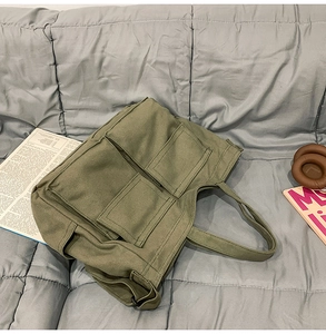 Gros plan détaillé du sac cabas en toile vert armée avec poches multiples pratiques