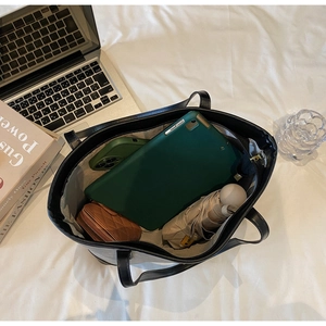 Detailed view of the large interior capacity of this black tote bag with everyday items