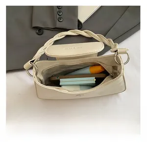 Detail view of cream chain bag interior showing capacity for phone and cosmetics