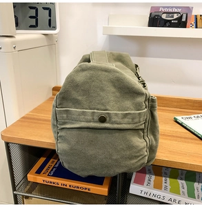 Nahaufnahme der olivgrünen Segeltuchtasche mit Retro-Metalldruckknopf im Vintage-Design