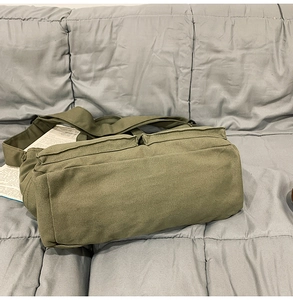 Vue détaillée du sac en toile vert militaire avec poches avant et bandoulière large