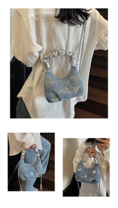 Dettaglio borsa in denim blu con fiocchi d'argento e manico metallico a pieghe