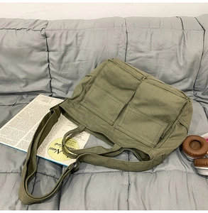 Détail du sac fourre-tout en toile vert olive avec poches avant et bandoulière réglable