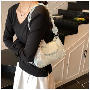 Detail view of light green shoulder bag featuring a lace bow and twisted woven strap