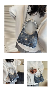 Dettaglio borsa a spalla in denim con farfalle argentate e tracolla a catena