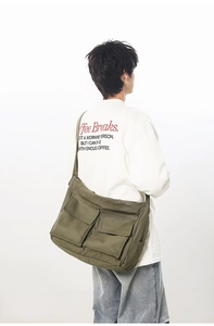 Détail du sac fourre-tout en toile vert armée avec grandes poches avant et poche latérale