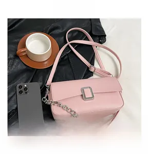 Detailed close-up of pink litchi grain faux leather bag with silver buckle and phone