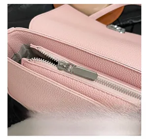 Close-up of pink lychee pattern leather bag showing silver metal zipper and stitching