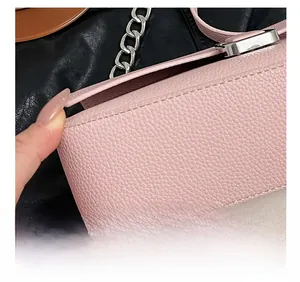 Close-up of pink lychee pattern leather bag with silver chain and precision stitching