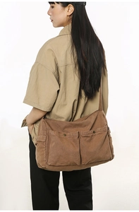 Seitenansicht der Retro-Canvas-Umhängetasche mit großen Taschen im braunen Vintage-Workwear-Stil