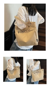 Dettaglio della borsa tote in tela beige con scritte marroni su scala di legno