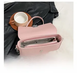 Detail view of pink pebble grain leather bag interior with zipper divider and metal chain