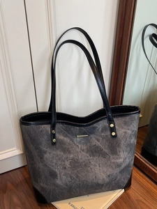Large gray washed canvas tote bag with gold metal trim and long handles for daily commute