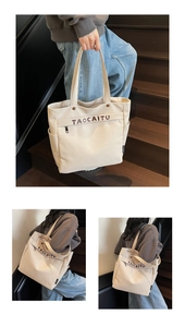 Dettaglio borsa tote in tela beige con tasca a zip e stampa di lettere marroni sul fronte