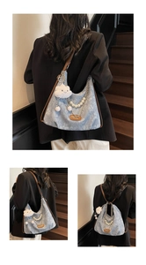 Detail showing blue floral canvas bag with pearl strap, silver chain and plush cloud charm