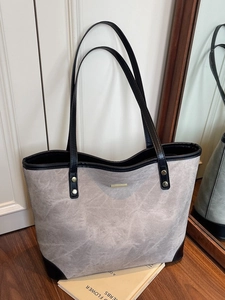Large grey marble texture tote bag with black straps and gold rivets on wooden floor