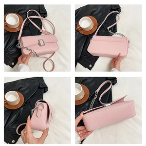 Detail view of pink lychee leather handbag featuring silver buckle and metal chain accents