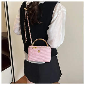 Pink quilted crossbody bag with gold handle shown from the back on a model