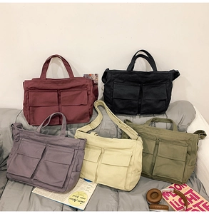 Détail de sacs fourre-tout en toile à plusieurs poches en diverses couleurs sur tissu doux