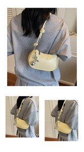 Detail of pale yellow pleated leather crescent bag with silver balloon dog charm