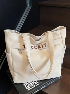 Large capacity off-white canvas tote bag with brown lettering and side pocket for daily use