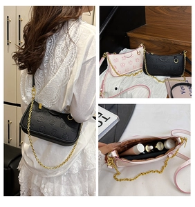 Detail of trendy crossbody bag interior holding lipstick and skincare on chain strap