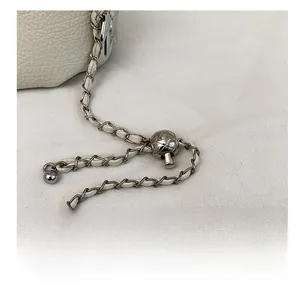 Macro detail of the adjustable silver chain strap with leather threading and metal slider