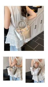 Silver metallic crossbody bag featuring pink ribbon bows and pearl heart charm details