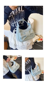 Close-up of light blue patent leather bucket bag featuring a large decorative bow detail