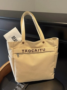 Minimalist beige canvas tote bag with shoulder straps and side pockets for work