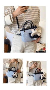Detail showing blue and white checkered woven handbag with a cute plush puppy pendant