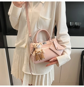 Pink faux leather crossbody bag with cute teddy bear charm and mini envelope wallet detail
