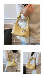 Detail of yellow pleated hobo bag featuring a chain strap and lucky horse charm